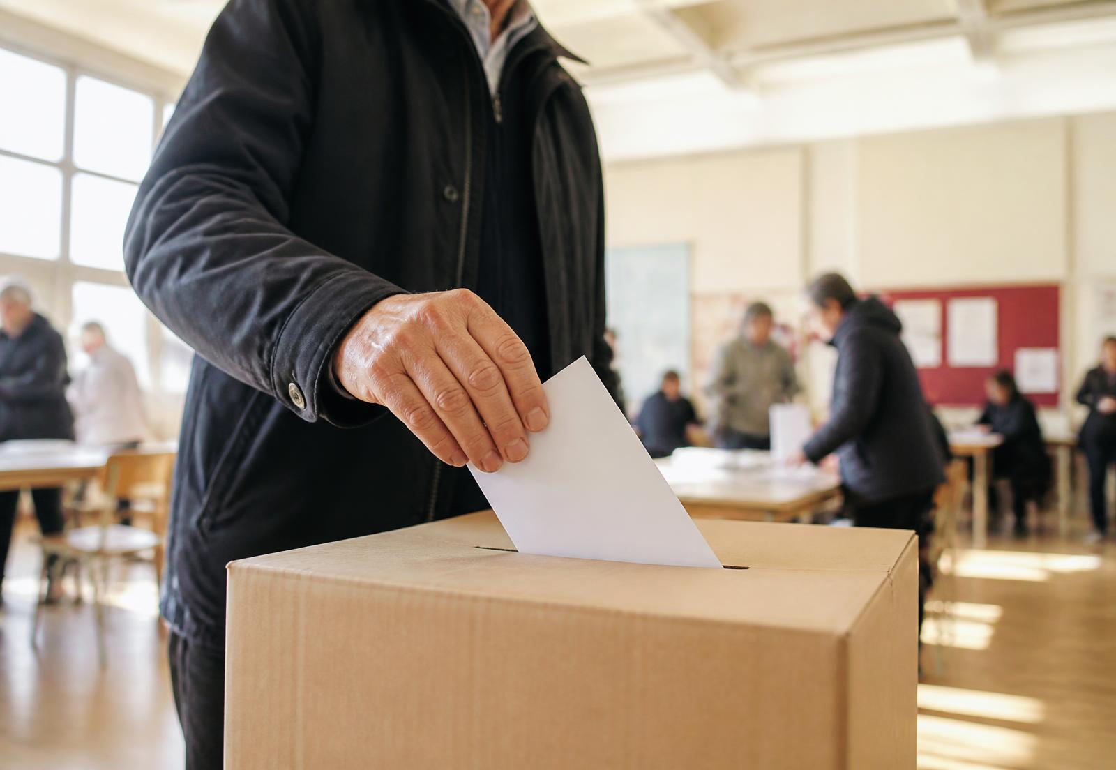 A voter placing a ballot into a ballot box